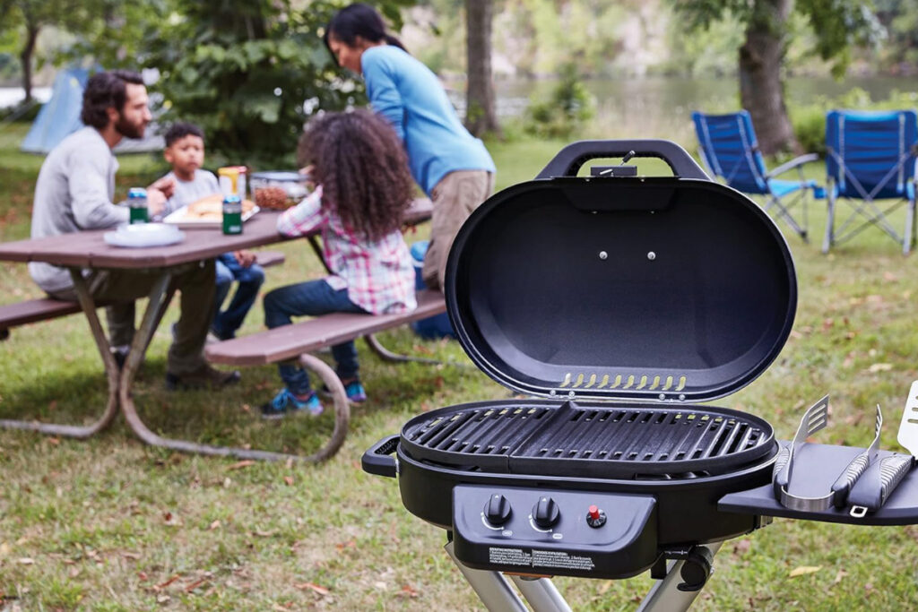 Coleman RoadTrip 225 Portable Stand-Up Propane Grill showcased outdoors, perfect for camping, tailgating, and backyard barbecues.