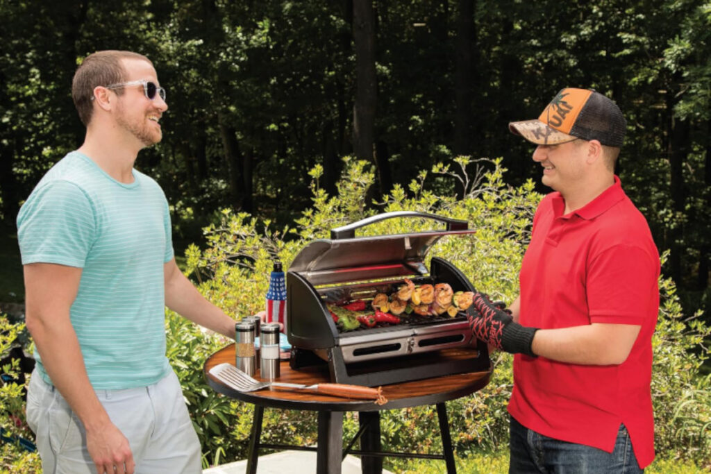 Delicious grilled burgers and vegetables showcased on the Cuisinart Grillster Portable Gas Grill, perfect for outdoor cooking and barbecues.