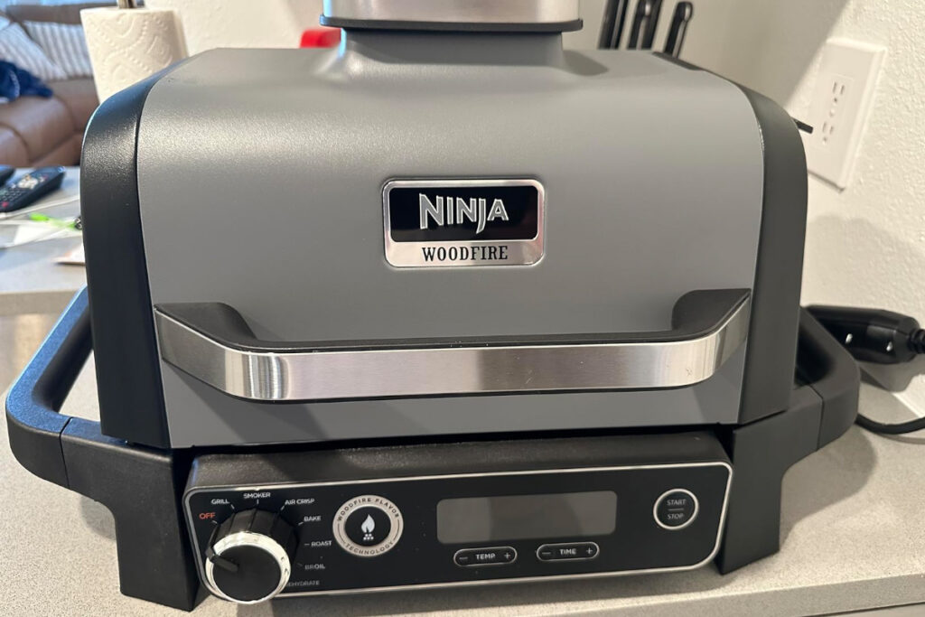 Ninja OG751BRN Woodfire Pro Grill and Smoker showcasing its sleek design and versatile cooking features for outdoor grilling and smoking enthusiasts.